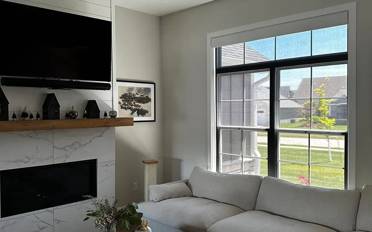 Wall-mounted TV above marble fireplace with soundbar