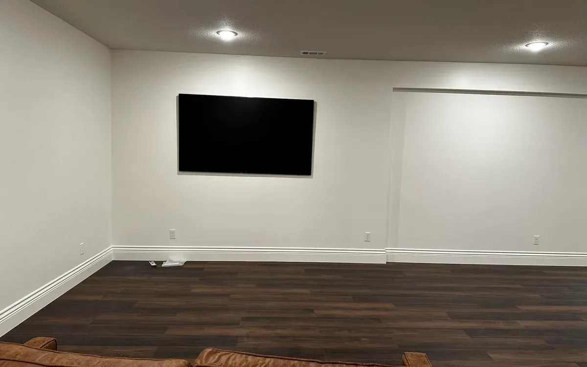 Basement entertainment area with large wall-mounted TV