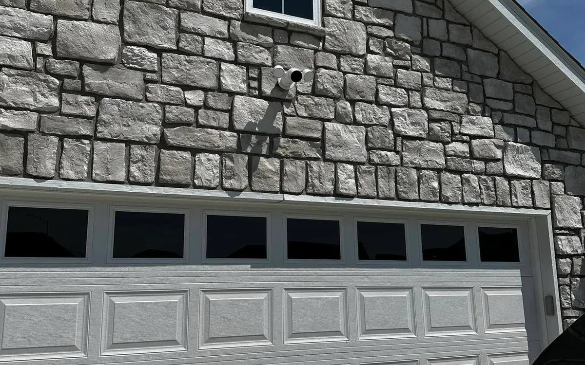 Exterior security camera mounted on stone facade