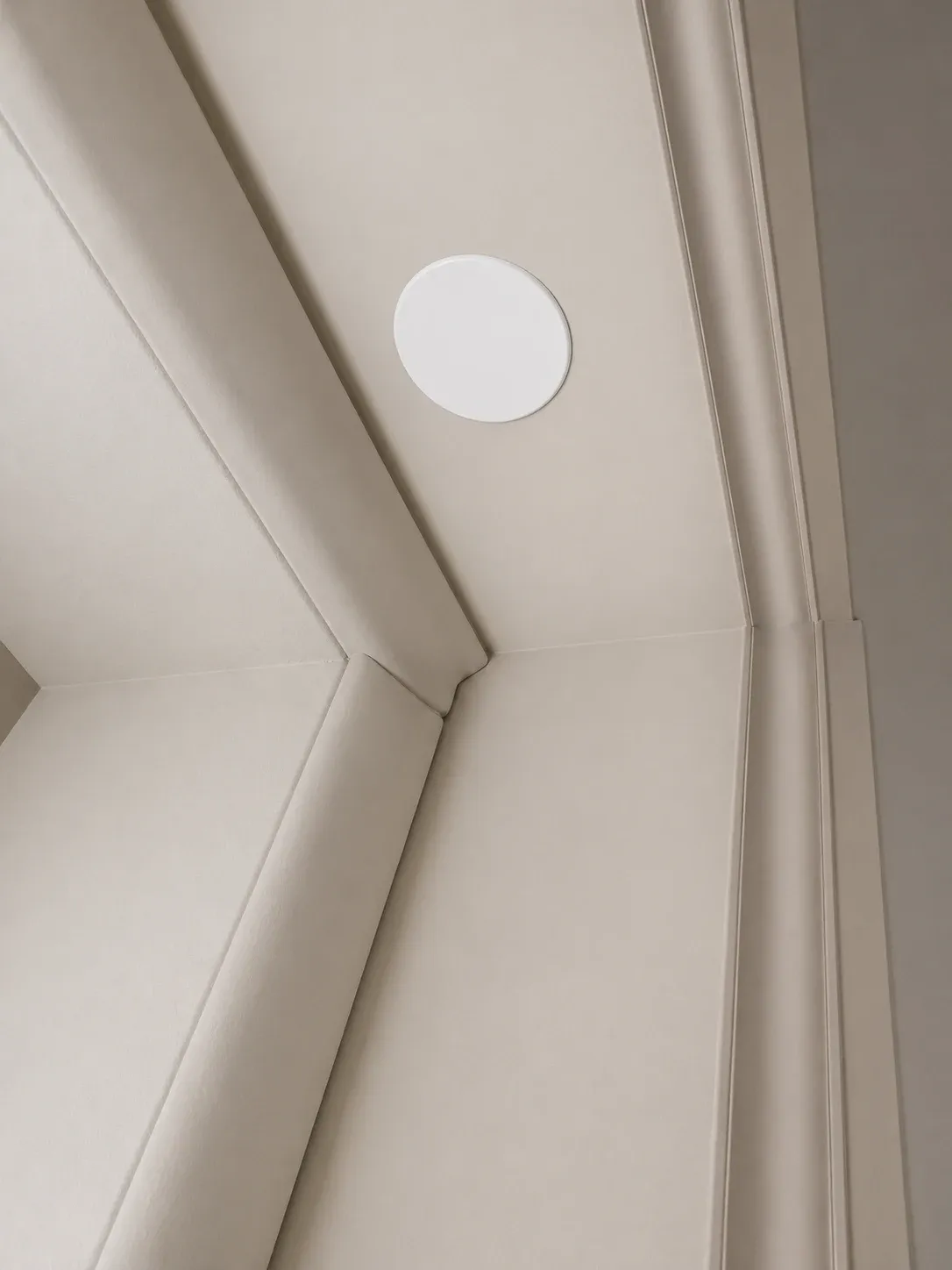 Recessed door sensor: a small white disc set flush into the door frame, almost invisible.